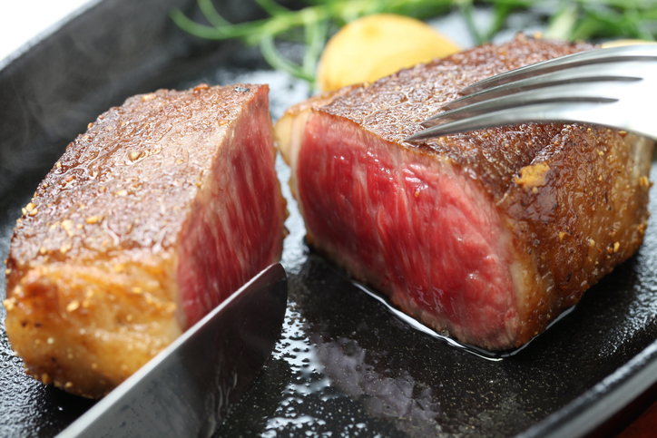 A juicy cooked steak with lots of marbling.