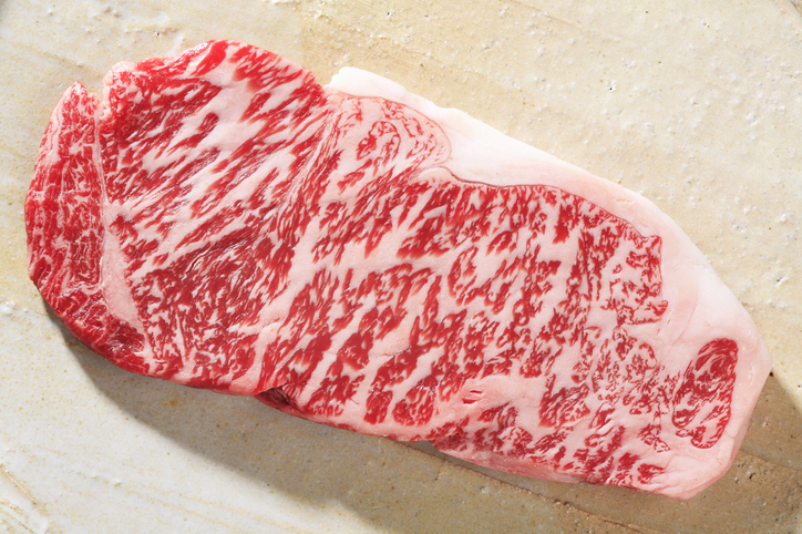 A raw steak highly marbled with fat.