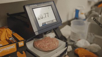 A gif of raw beef being analyzed in a machine for fat content. 